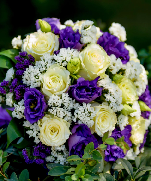 A bouquet of flowers with purple and white roses.